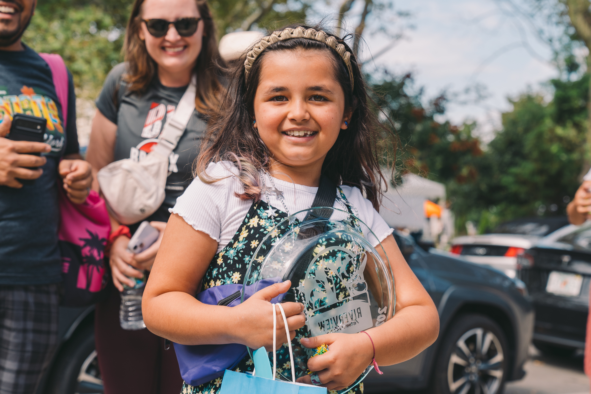 The Kid's Apple Dessert Baking Contest Champion Nora, age 8, stands proud holding her Riverview Farmers Market pie plate prize.