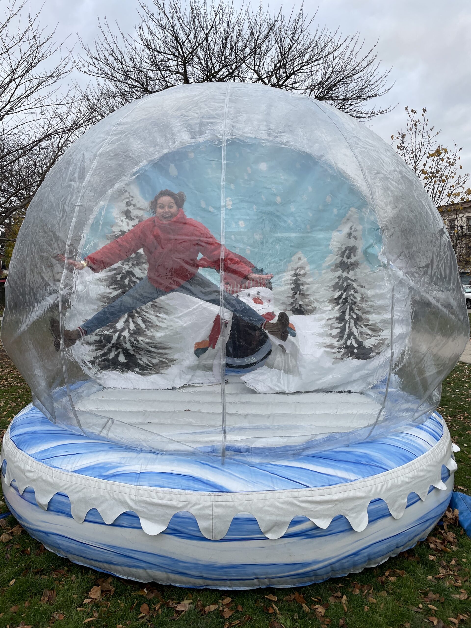 Michelle Berckes, Owner and Executive Chef of Busy Bee Organics, does a jump split in the inflatable winter snow globe at last year's Heights Holiday Market.