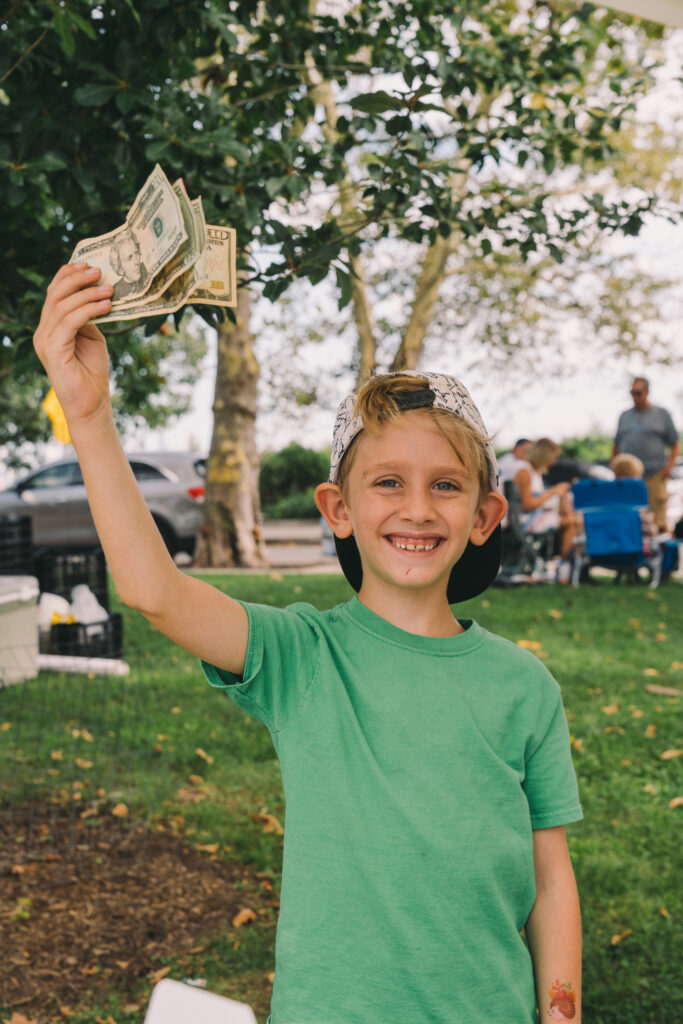 Wiley, the 50/50 raffle winner, proudly shows off his winnings by holding the bills in the air. 