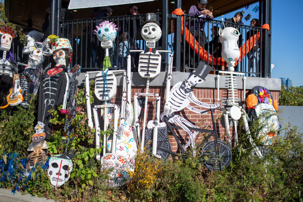 Selection of skeleton puppets set up against a brick wall after the parade / march is over at the 2025 Day of the Dead Festival